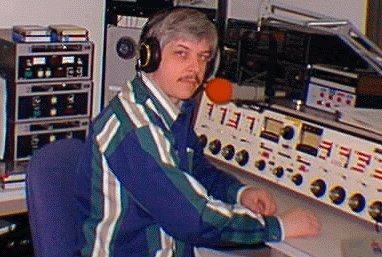 A radio operator working at a broadcast console